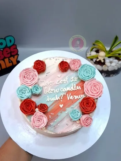 A modern take on a floral cake with a painted watercolor effect and piped rosettes.