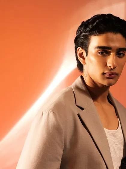A close-up of the slicked-back hair and glowing skin. This is a perfect example of clean, professional men's grooming.