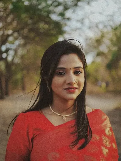 A vintage-style 35mm portrait of a woman in a red saree, with a soft focus and warm tones creating a nostalgic feel.