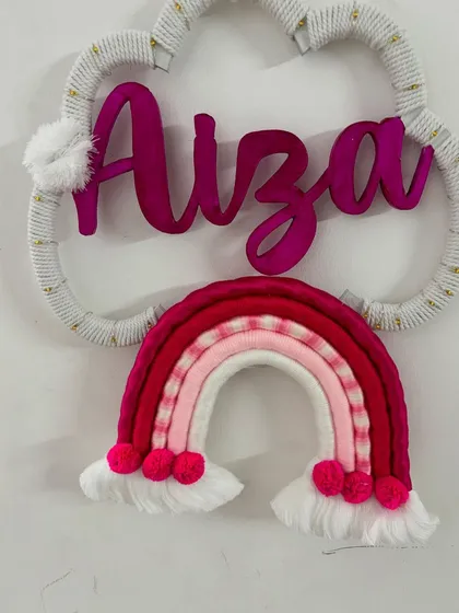 A clear shot of the 'Aiza' name hanging, showcasing the pom-pom details on the rainbow and cloud.