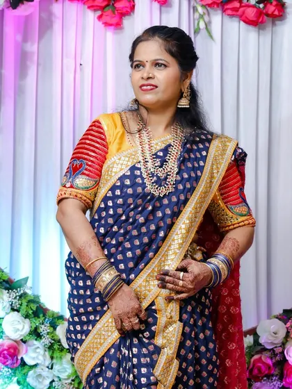 A close-up of the client in the blue Nauvari, showing her happiness and the detailed jewellery.
