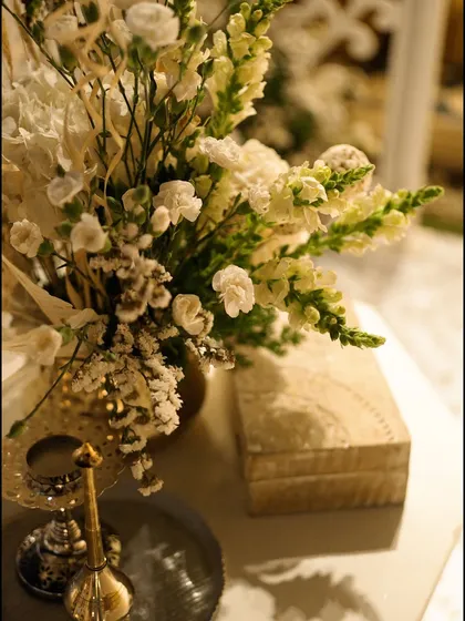 A delicate arrangement of white flowers next to a carved wooden box, adding to the serene and soulful ambiance.