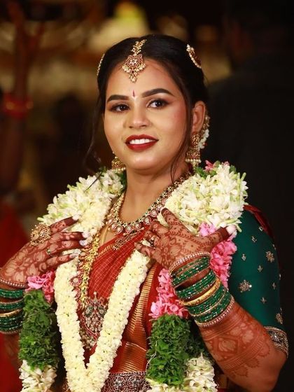 A happy bride during her wedding, her hands adorned with garlands and beautiful henna.