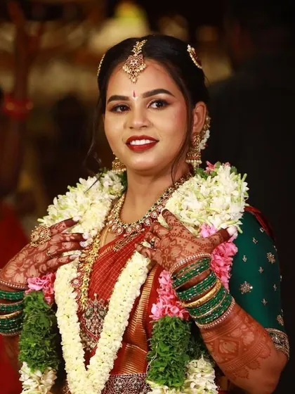 A happy bride during her wedding, her hands adorned with garlands and beautiful henna.