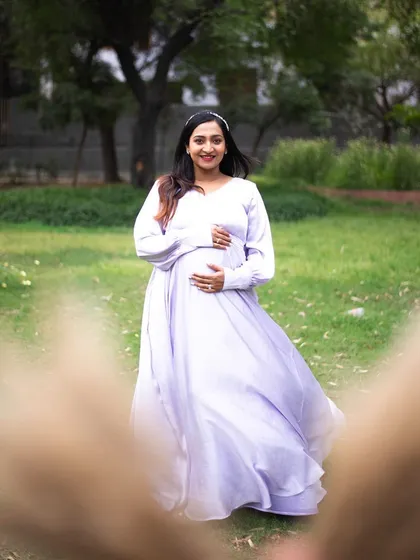 A solo maternity portrait is a beautiful way to celebrate your journey. This mom-to-be is wearing a flowy lavender gown that catches the light perfectly in this outdoor park setting. I guide my clients with simple movements, like a gentle twirl, to create images that feel joyful and full of life.