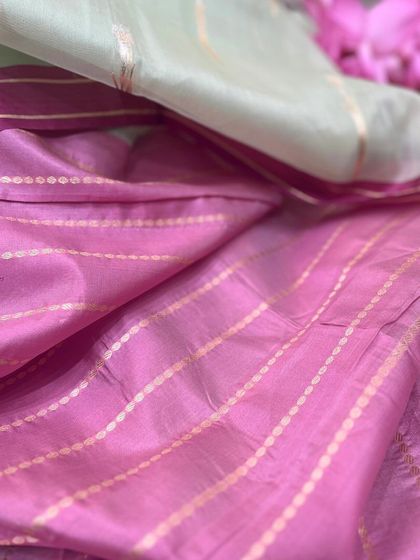 A closer look at the texture and drape of our pink and green Tissue Silk saree. The fine golden stripes add a touch of shimmer to the delicate fabric.