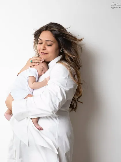 A mother's embrace is the safest place. This portrait captures the quiet, loving moments as a mom snuggles her sleeping newborn close.