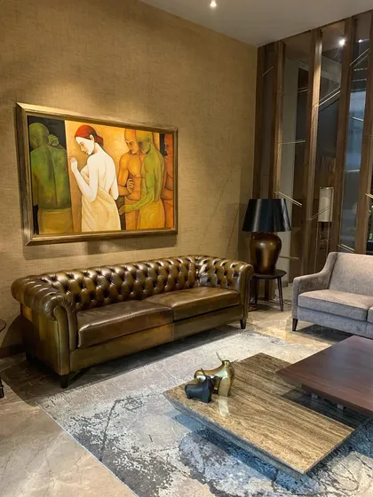 Site diaries: a warm palette of taupe, bronze, copper, and olive infuses this home with a quiet luminosity. This vignette shows a classic leather chesterfield sofa against a backdrop of rich textures and art.