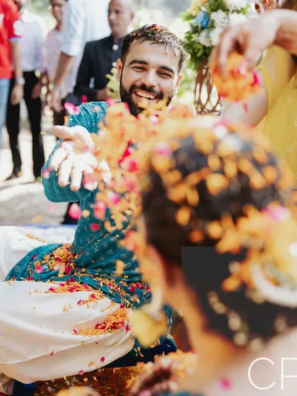 The groom playfully throws flower petals during the Haldi. I get right into the action to capture these fun, interactive moments.