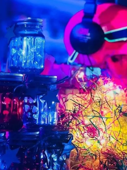 A close-up of the neon-drenched decor. Mason jars filled with lights and a skull wearing headphones contribute to the vibrant, glowing aesthetic of the retro disco theme.
