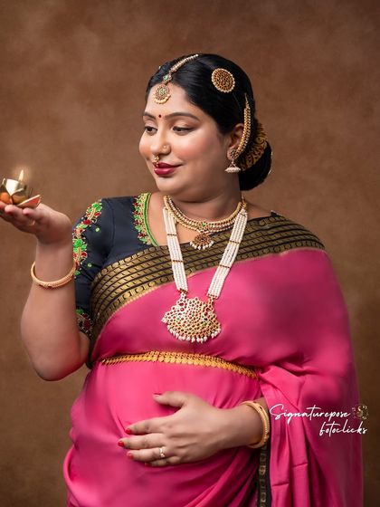Holding a diya, this portrait symbolizes light and life, adding a spiritual dimension to the maternity shoot.