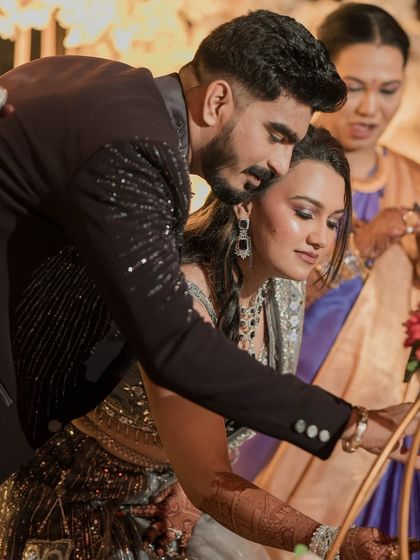 A candid moment during the reception festivities. The couple looks happy and relaxed, with the bride's elegant makeup and hair looking flawless throughout the event.