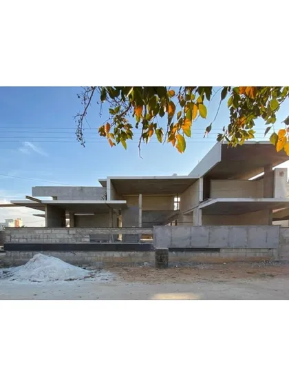 A before-and-after comparison, showing the raw concrete structure of The Quarry House during construction. This highlights the journey from a bare shell to a finished home that is a "visual cascade of volumes."