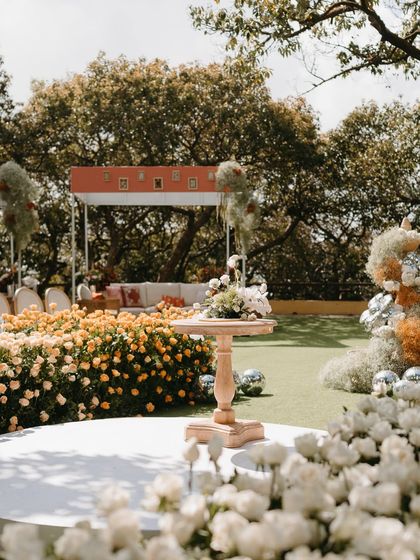 A beautiful overview of the garden ceremony, showcasing the ombré floral aisle, the central stage, and the modern lounge canopy.