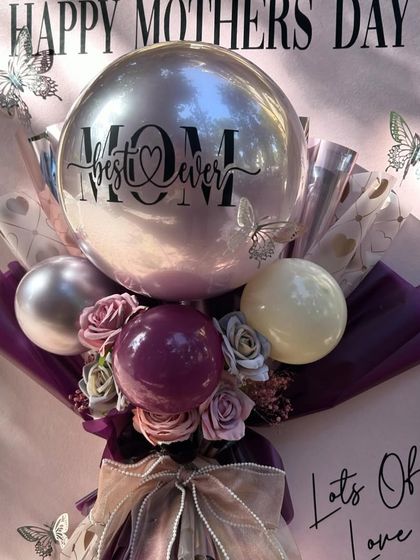 The "Inflated Affection" balloon postcard, seen here in the sunlight, shines with its metallic "Best Mom Ever" balloon and rich purple wrapping.
