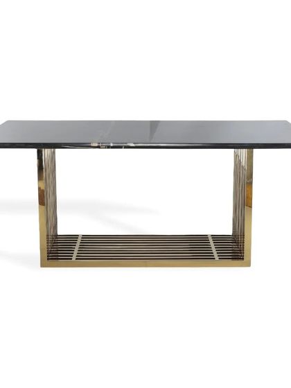 This image highlights the dining table's design, with its sleek grey glass top and the intricate, cage-like PVD gold base that provides both support and visual interest.