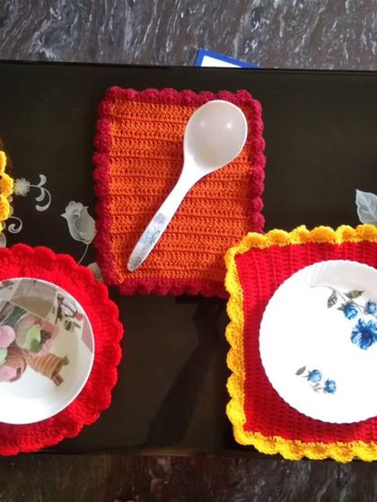 A set of my colorful handmade table mats in various shapes and sizes, perfect for protecting your surfaces with a pop of color.