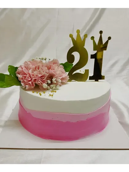 A 21st birthday cake with a pink ombre design. The look is completed with a fresh carnation and a golden "21" topper.