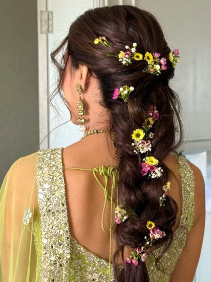 A side view of the floral fishtail braid, showing how the flowers are scattered throughout for a natural, whimsical feel.