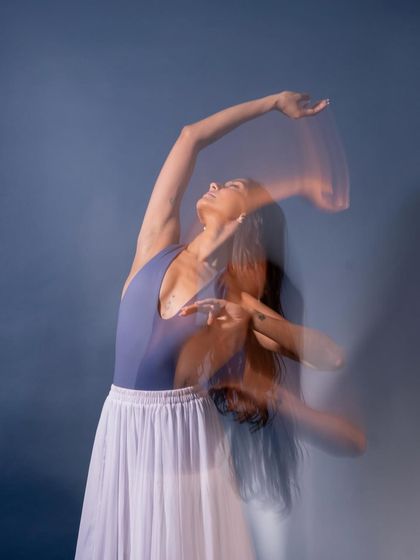 A long-exposure shot from the 'Swan Song' series, capturing the flow of movement. This technique creates a ghostly, ethereal quality that visualizes the path of the dance.