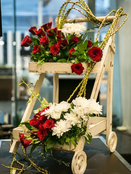 A charming floral arrangement on a rustic wooden cart. We use small, thoughtful decor elements like this to add character and beauty to every corner of your event space.