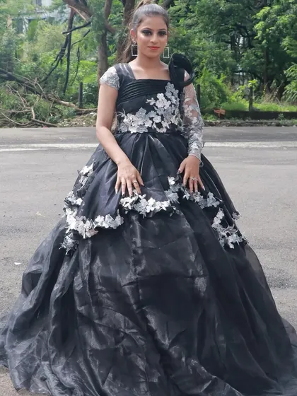 The full view of a dramatic black gown, with makeup done by a student to match its elegance.