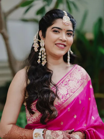 A portrait of Reeya during her Haldi ceremony. The fresh matte glam with subtle pink hues enhances her natural glow.
