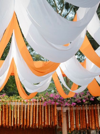 A view looking up at the billowing orange and white fabric drapes that created a festive canopy for the outdoor Haldi.