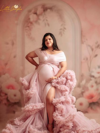 Feeling confident and beautiful in this gorgeous pink gown. The thigh-high slit and ruffled design make it a perfect choice for a glamorous maternity look.