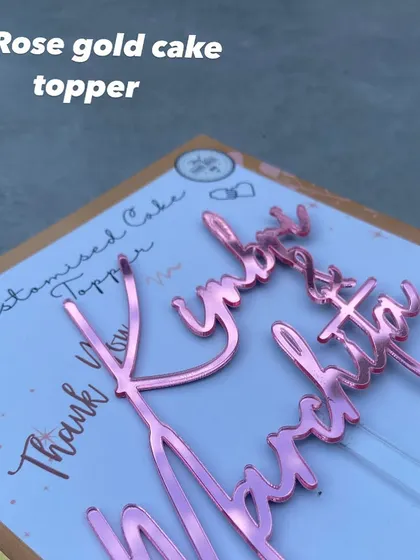 A close-up of a "Kimbri & Marchita" topper in our beautiful rose gold mirror finish, a warm and trendy alternative to classic gold.