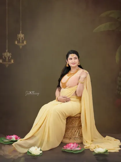 Glowing in a soft yellow saree, this mother-to-be looks like a goddess. The setup with lotus flowers and traditional lamps adds a divine touch, creating a serene and beautiful portrait.