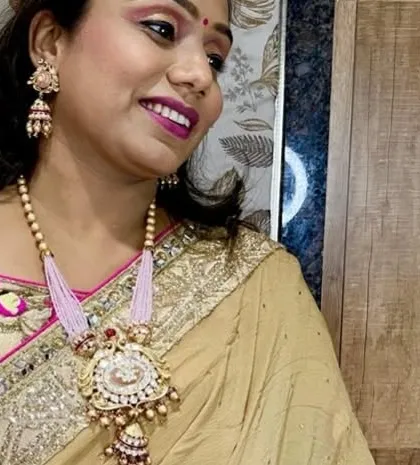 A side profile showing the delicate jhumki-style pendant and the beautiful light pink beading of the necklace.