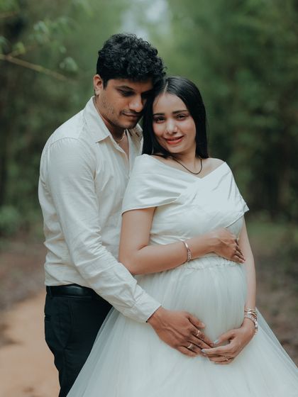 A happy and radiant couple's portrait. The simple white maternity gown is a versatile choice that works beautifully for any outdoor setting.