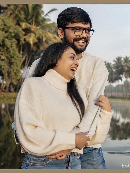 A candid moment of laughter and joy. This photo captures the genuine happiness of Amrutha and Varun during their nature-filled pre-wedding shoot.