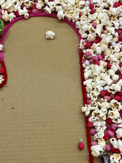 We made this giant candy cane art using popcorn and colored chickpeas. It's a wonderful collaborative art project for a Christmas party that engages the senses of touch and smell.