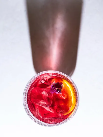 A top-down shot of a red cocktail, playing with its shadow. This artistic approach creates a dramatic and visually interesting image.