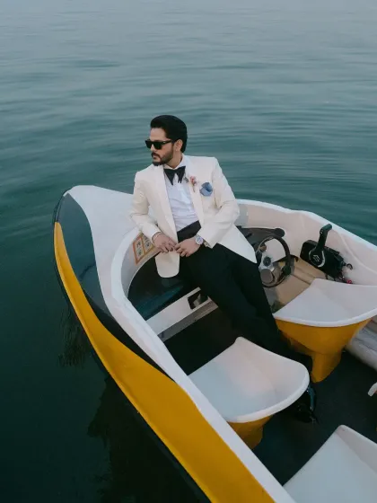 The groom, Christy, looking sharp and stylish during his solo portrait session on the boat. This shot captures the cool, celebratory mood of his island wedding day.