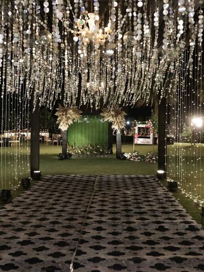 Walking through a tunnel of shimmering silver discs and fairy lights creates a truly immersive and magical experience for guests as they enter.