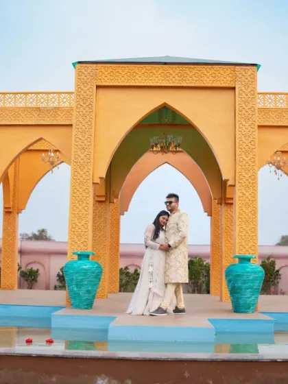 Regal and romantic. This couple looks stunning in a coordinated white lehenga and a floral sherwani, perfect for a pre-wedding shoot at a palace-themed location.