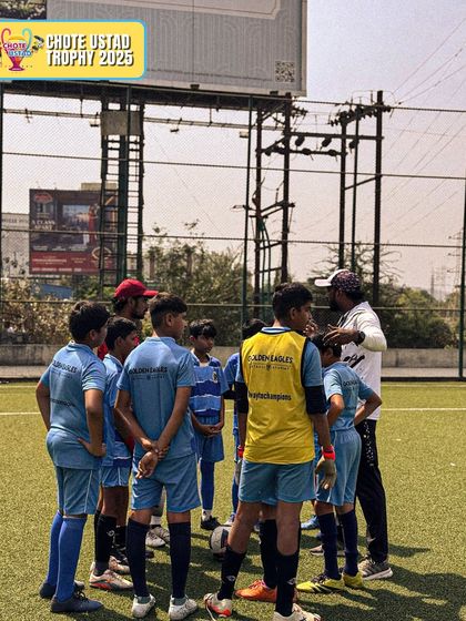 A coach huddles with the U12 team during a break at the Chote Ustad Trophy. These moments are crucial for discussing tactics and motivating the players.