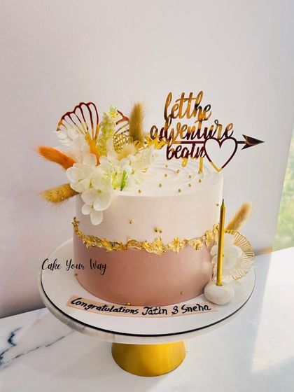 A beautiful cake for celebrating new beginnings, with dried flowers and a "let the adventure begin" topper.