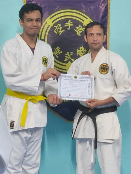 An adult student receives his 8th Kyu (yellow belt) certificate. His commitment to learning the traditional way is commendable.