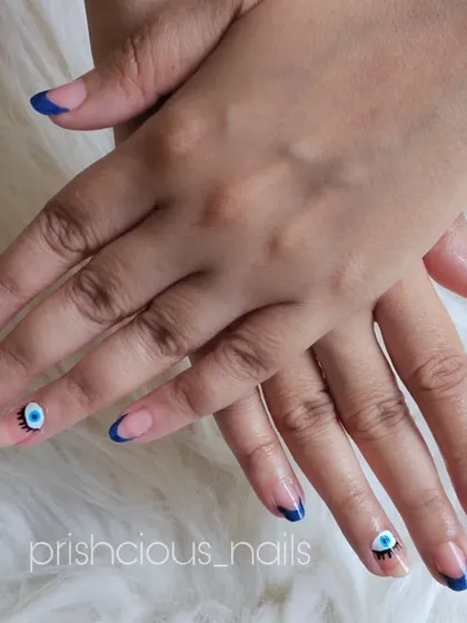 A different take on the evil eye trend, this time with winking eyes on the accent nails combined with a classic blue French tip.
