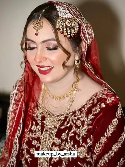 The pure joy on a bride's face is everything. Her makeup is classic and radiant, with a bright red lip and shimmery eyes that light up her smile.