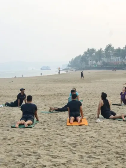 The group moving into Cobra Pose (Bhujangasana). This gentle backbend helps strengthen the spine and open the heart, and practicing it together by the sea amplifies the feeling of release and renewal.