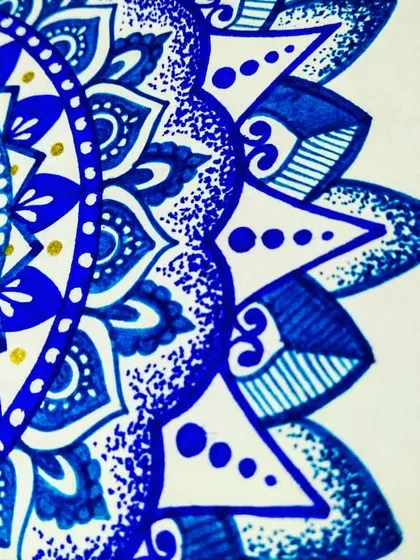A close-up of the blue semi-mandala. You can see the different pen strokes, from solid fills to delicate lines and dots, which create a rich and varied texture.