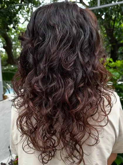 Curly and proud. I gave her curls a new life with a fresh cut, including a fringe, and subtle reddish-brown highlights to define the texture. Embracing your natural curls is always a good idea.