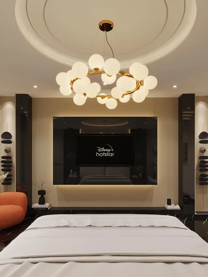A direct view of the entertainment wall in the opulent master bedroom. The television is seamlessly integrated into a custom-built unit, flanked by decorative panels and complemented by a modern globe chandelier.