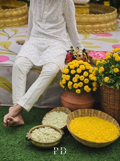 A relaxed moment during the Haldi ceremony. The decor, with its earthy pots and bright yellow flowers, creates a warm and inviting atmosphere.