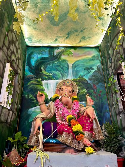 A different angle of the waterfall-themed decoration, showing the painted ceiling that adds to the immersive effect. The hanging vines with fairy lights make the space feel magical and alive.